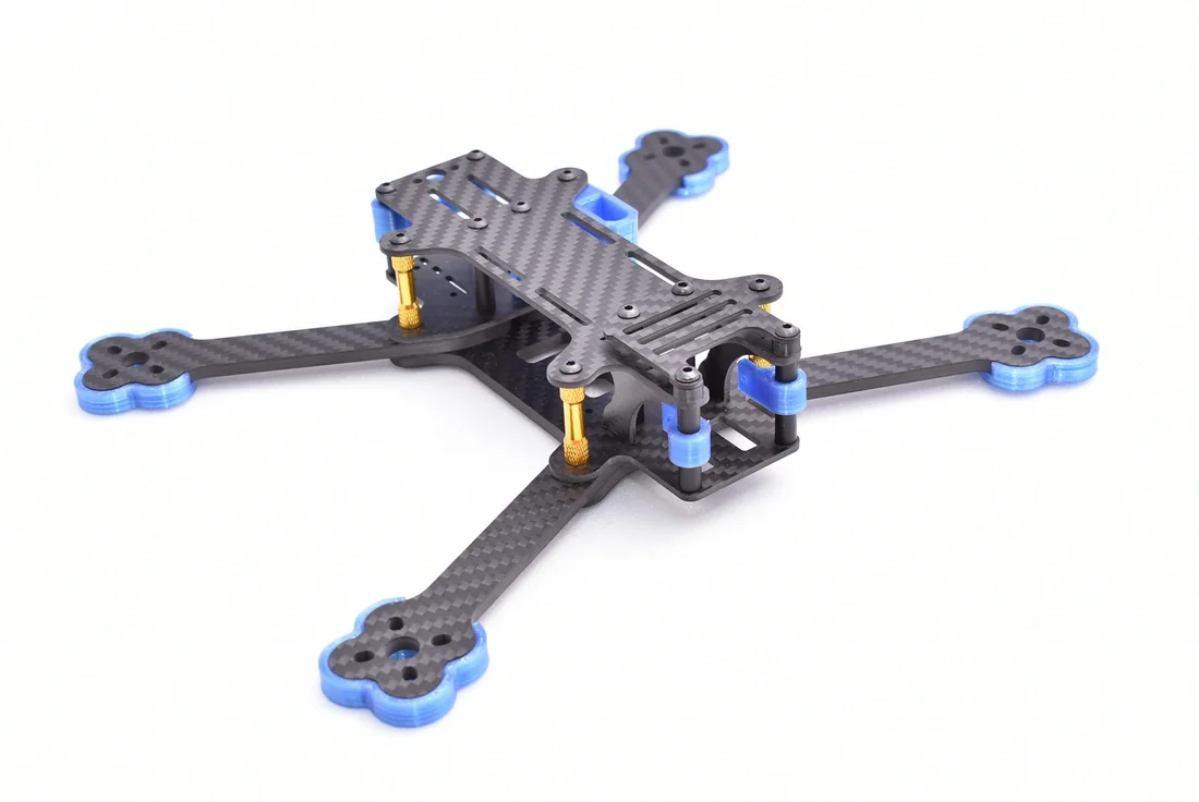 Bare carbon-fiber quadcopter frame with blue feet and yellow standoffs